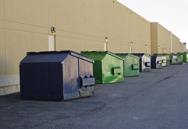 a construction worker moves construction materials near a dumpster in Bristow